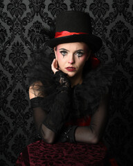 Close-up  glamour portrait of circus burlesque model wearing top hat and gothic gloves, theatrical...