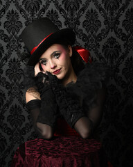 Close-up  glamour portrait of circus burlesque model wearing top hat and gothic gloves, theatrical...