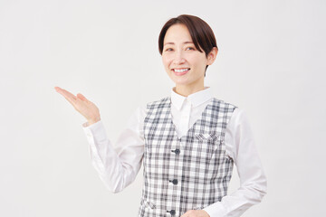 女性　事務員　手のひらで左側を指す　白背景