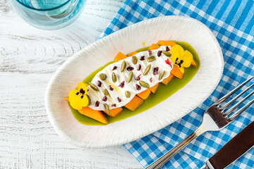 Zucchini and yogurt appetizer with capers and edible flowers