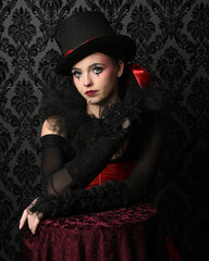Close-up  glamour portrait of circus burlesque model wearing top hat and gothic gloves, theatrical...