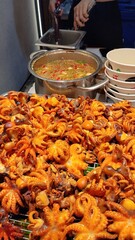 Vibrant Asian Street Food Stall with Grilled Baby Octopus and Variety of Snacks