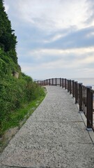 초여름 구름 낀 하늘과 바닷가 산책길