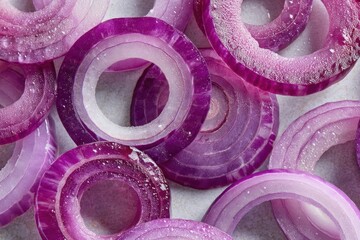 Freshly sliced red onions display a rich palette of purples and whites, highlighting their crisp texture and juicy appeal