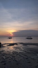 Golden Sunset Over Calm Ocean with Traditional Fishing Boats