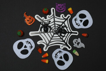 Halloween with skull, ticks, orange maple leaves, bats, spiders on black background with space for...