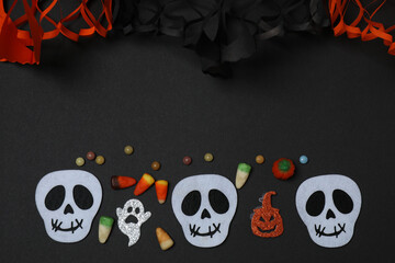 Halloween with skull, ticks, orange maple leaves, bats, spiders on black background with space for...