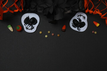 Halloween with skull, ticks, orange maple leaves, bats, spiders on black background with space for...