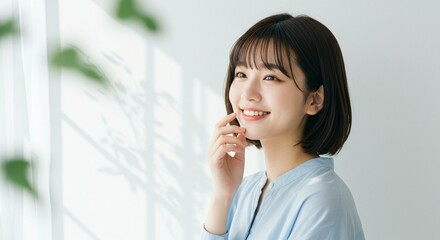 Smiling asian woman looking out the window with hand on her face