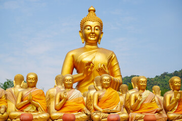 The big golden Buddha statue among many small Buddha statues in countryside public temple named MAKHA BUCHA BUDDHIST MEMORIAL PARK, select and soft focus.