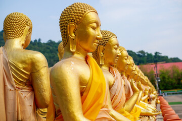 The big golden Buddha statue among many small Buddha statues in countryside public temple named MAKHA BUCHA BUDDHIST MEMORIAL PARK, select and soft focus.