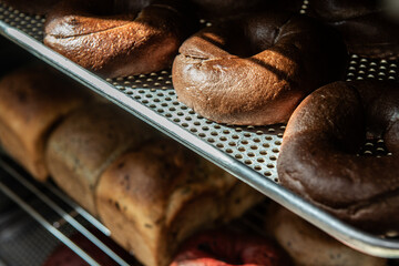 Freshly baked buns on a metal rack in a bakery.
