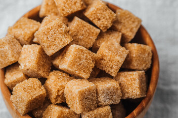 Brown sugar cubes in a wooden bowl create a rustic kitchen aesthetic