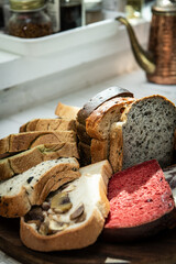 Variety of bread on wooden cutting board in a bakery shop.