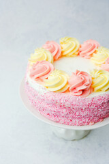 Delicious cake topped with colorful swirls presented on a white stand