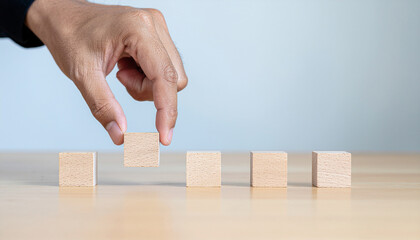 Concept of hand align. A horizontal line of  blank small wooden blocks. Strategic business component concept.
