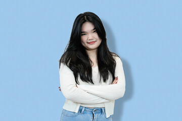 young woman with crossed arms casual pose in blue background
