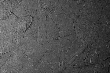 Black textured background surface with cracked pattern