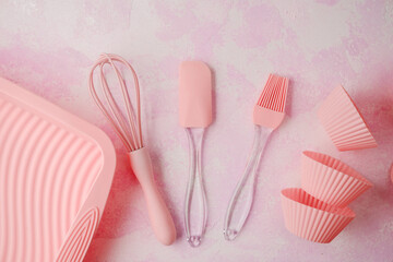 Pink silicone baking utensils on textured pink background
