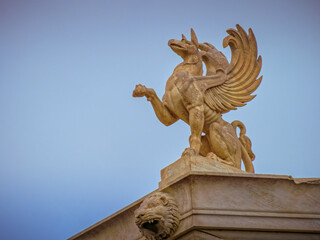 Majestic griffin sculpture on the National Academy of Greece in Athens, embodying ancient myths. Space for your text and logo.