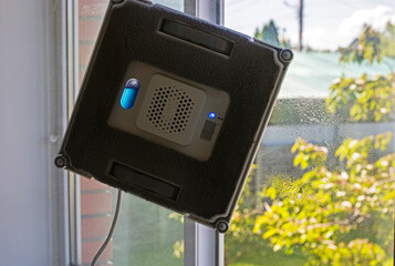 window cleaning robot sprays on window while cleaning