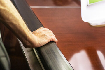 man's hand holding the railing on the escalator