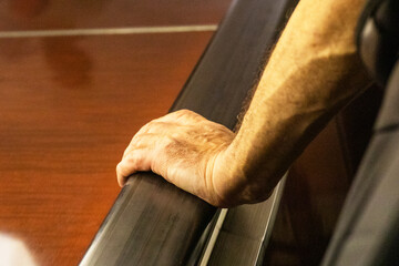 man's hand holding the railing on the escalator