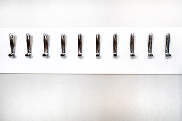 stylish modern metal hooks for clothes and bags on a light wall