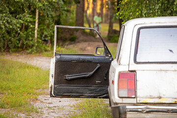 open door of an old car in the forest. weekend day