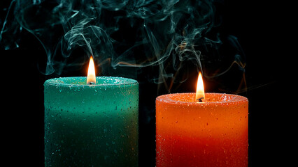 Sparkling teal and orange candles with wispy smoke