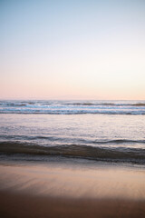 Gentle beach waves with pastel reflections and soft ocean light