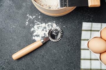 Baking preparation with flour, eggs, and kitchen tools on a countertop