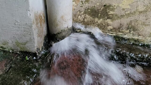 Outer pipe of gutter flowing with rain water