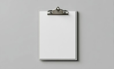 A blank white sheet of paper is held firmly within a simple grey clipboard, set against a neutral grey backdrop