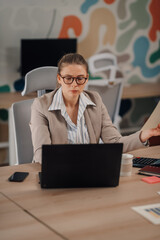 Focused businesswoman working on laptop in modern office