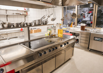 Ready-to-use stainless steel kitchen with professional equipment, induction stove, cookware, and...