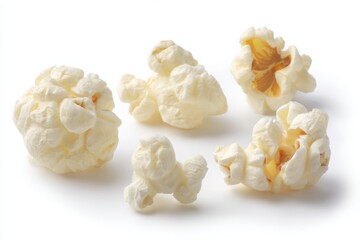 A close up view of several pieces of popcorn scattered on a plain white background surface studio shot