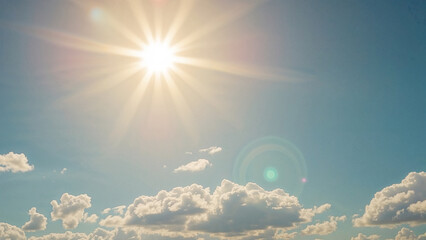 Bright sun shining through fluffy clouds on a clear day daylight
