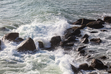 The ocean is rough and the waves are crashing against the rocks