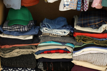 Piles of folded clothes filling closet shelf space