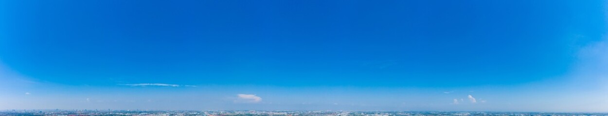 Panoramic view of bright blue sky with fluffy white clouds scattered across, symbolizing fresh air and peaceful nature, perfect for backgrounds or environmental design.