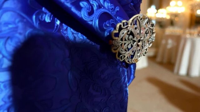 Blue fabric chair with brooch in elegant banquet hall
