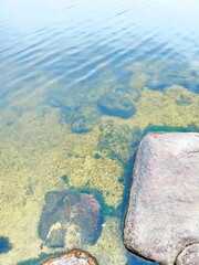 Amazing colorful background of the water surface of the Dnieper disturbed by a light wind over a stone bottom that shines through the water column.