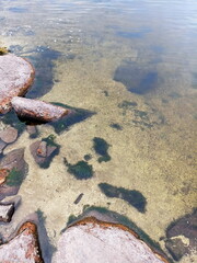 Amazing colorful background of the water surface of the Dnieper disturbed by a light wind over a stone bottom that shines through the water column.