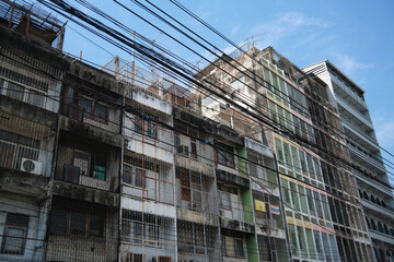 Weathered Urban Building Heavily Obscured by Dense Overhead Wires