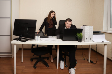 Professional Woman Explaining Business Documents to Male Colleague at Office Desk