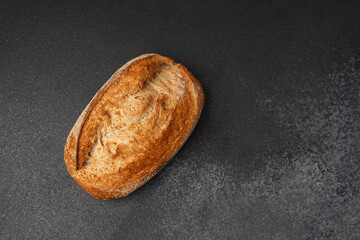 Freshly baked artisan bread with a golden crust on a dark surface