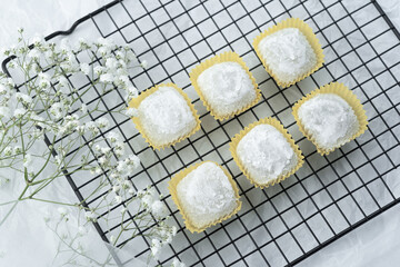 Soft pastel treats displayed on a decorative wire rack with flowers