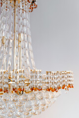 Intricate chandelier with clear crystals and amber accents illuminating a room