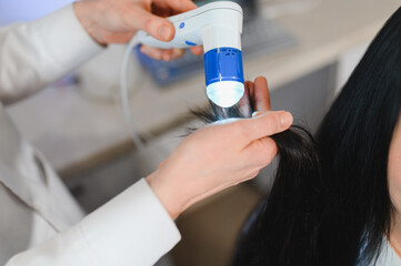 Doctor diagnoses the structure of the hair. Consultation with a trichologist